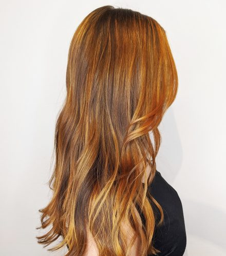 woman's hair with deep red to blondish balayage highlights