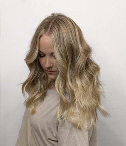 Woman looking sideways and down showing off blonde highlights
